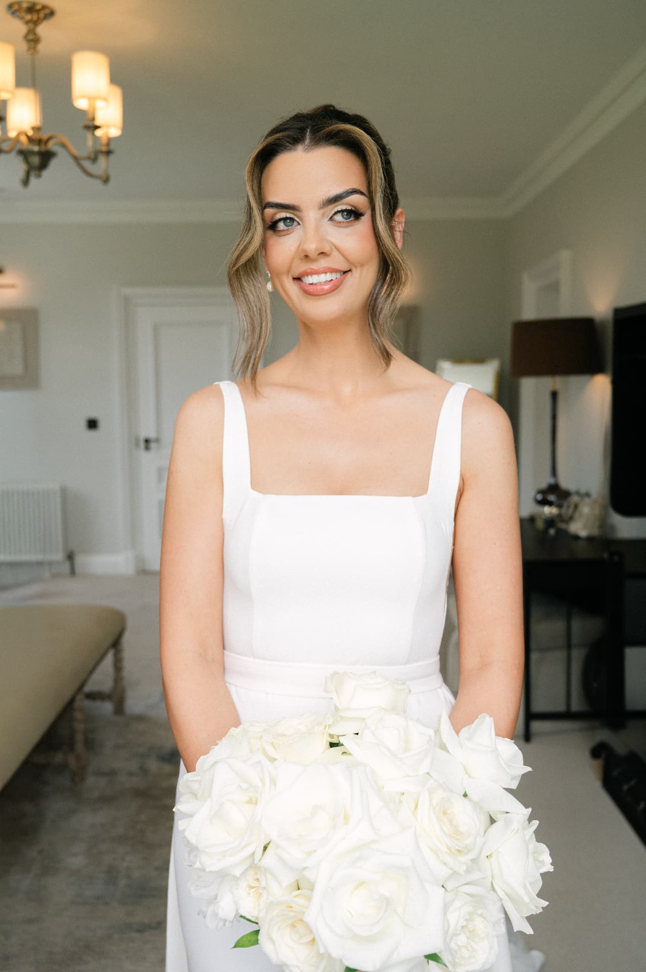 Bride holding a bouquet of white roses before the ceremony