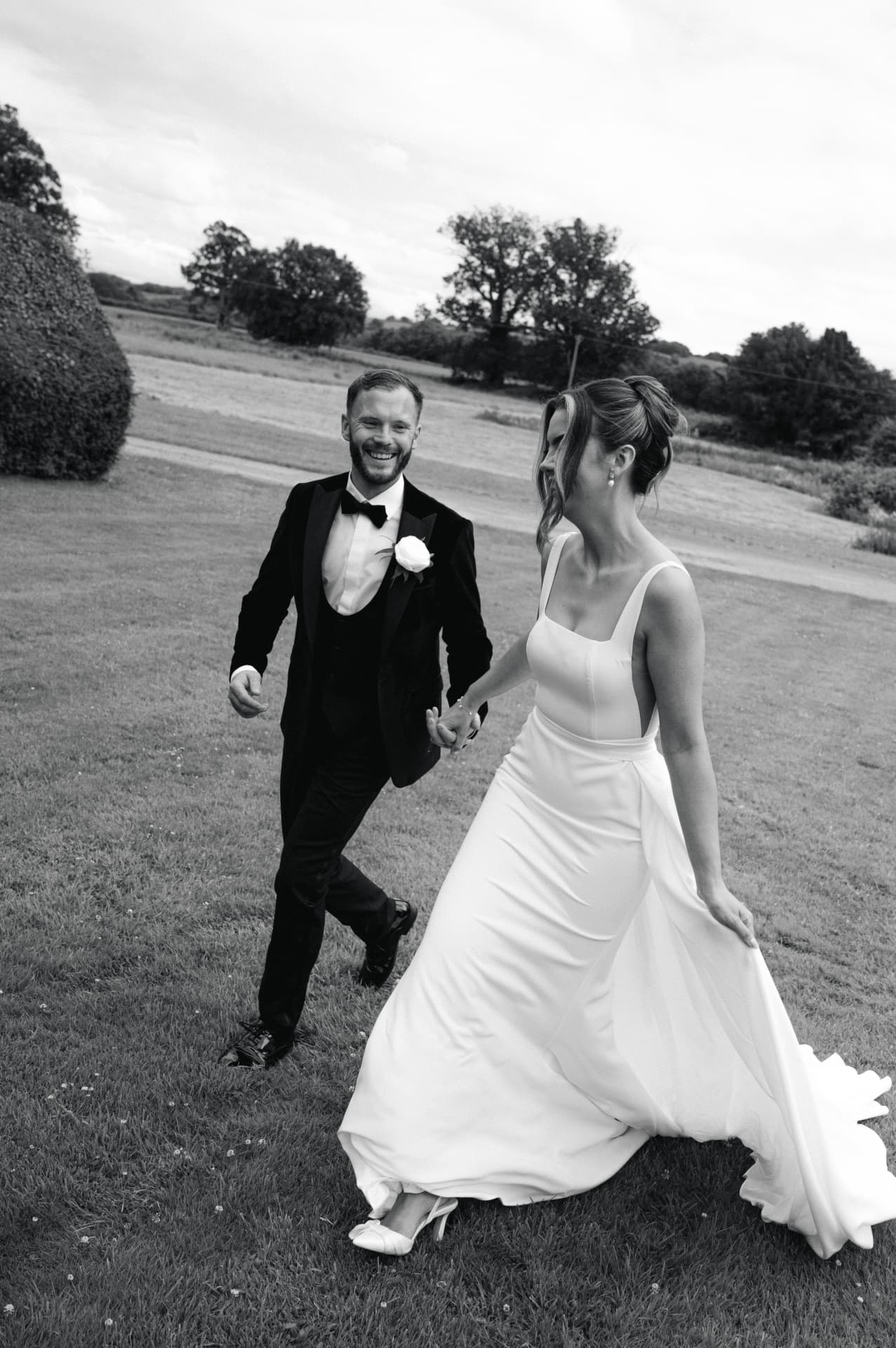 Bride and groom walking hand in hand through the grounds