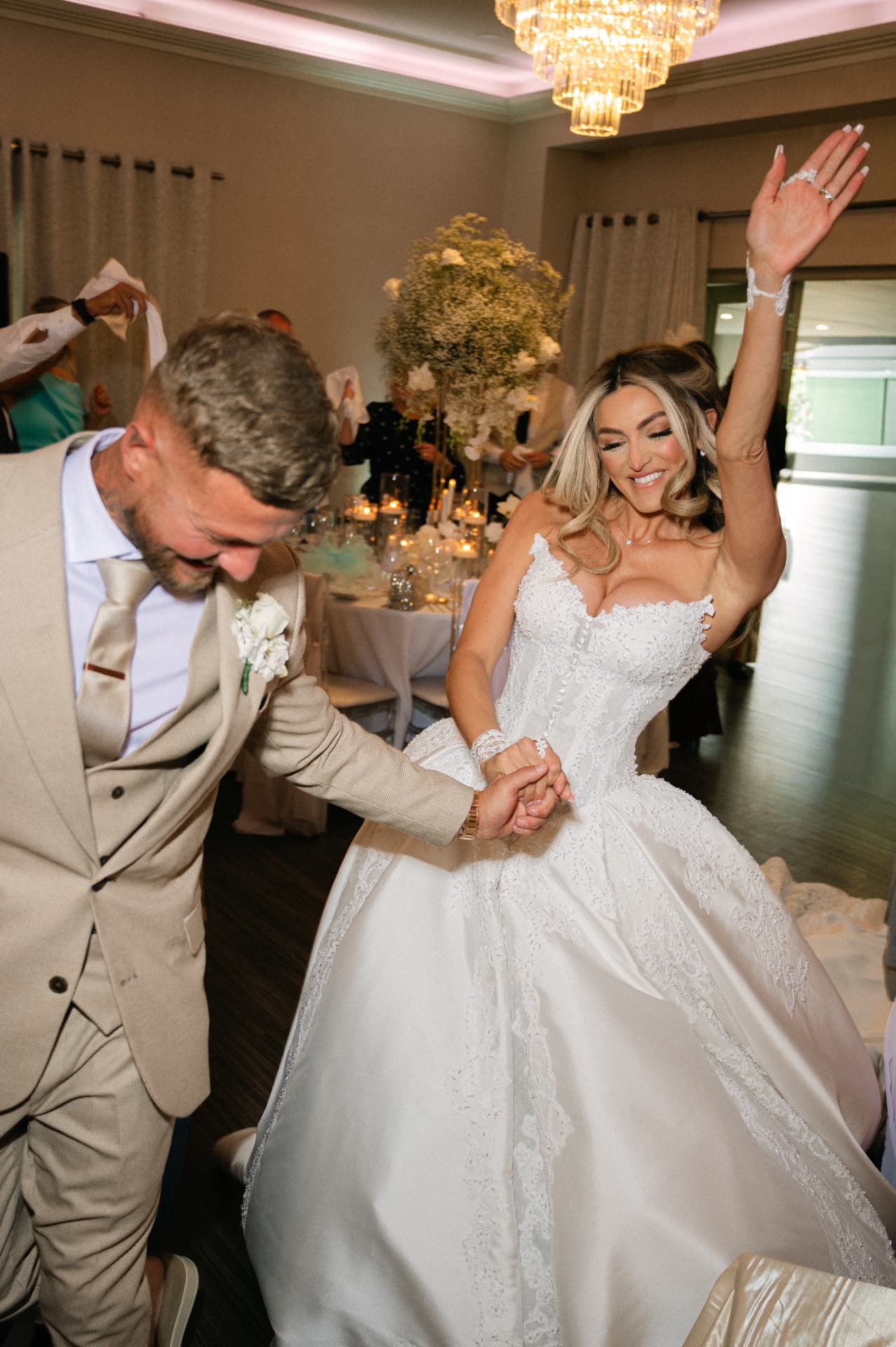 Bride and groom dancing under a chandelier at a wedding reception