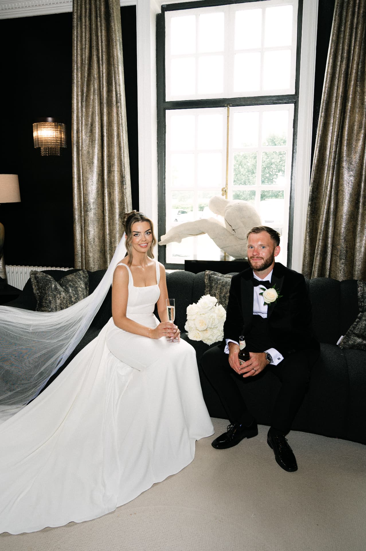 Newlyweds seated together in an elegant drawing room